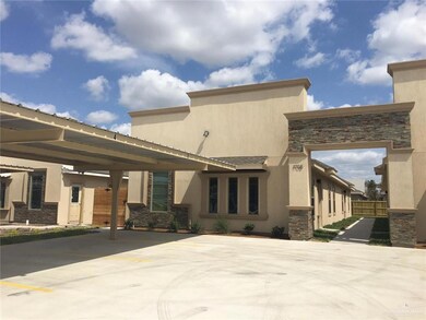 Back of property featuring stone siding, fence, and stucco siding