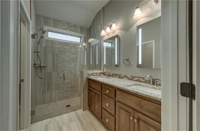 Large zero-entry tiled master shower with dual sho