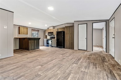 Kitchen with black appliances, vaulted ceiling, a