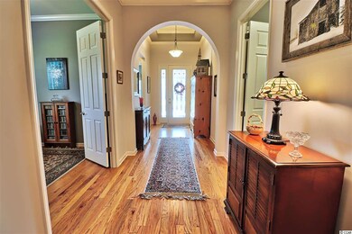Wood floors, tray ceiling and arched doorways welc