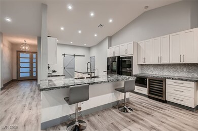 Kitchen featuring a sink, a barn door, beverage co
