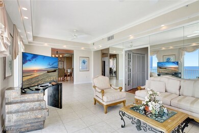 Living room with light tile patterned flooring, visible vents, recessed lighting, and ceiling fan with notable chandelier