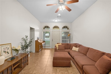 Living room with tile floors and a ceiling fan