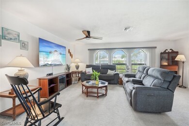 Living room featuring ceiling fan and light carpet