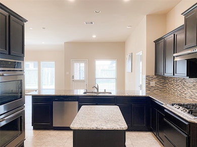 Gourmet kitchen with granite countertops, central island, double oven, gas range and exhaust vent