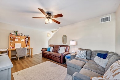 Living room featuring a ceiling fan, wood finished