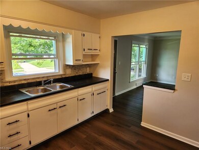Kitchen with backsplash, dark countertops, white c