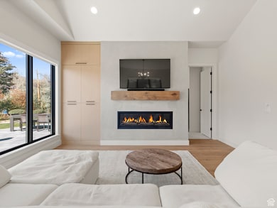 Living room featuring light wood-style floors, a large fireplace, and recessed lighting
