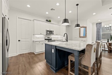 Kitchen with pendant lighting, white cabinets, orn