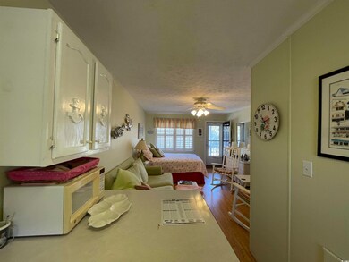 Bedroom with a textured ceiling, wood-type floorin