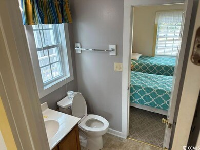 Bathroom with tile patterned flooring, a healthy amount of sunlight, toilet, and vanity
