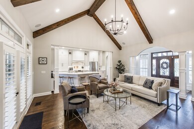 The living room has custom wood beams that highlight this impressive vaulted ceiling!