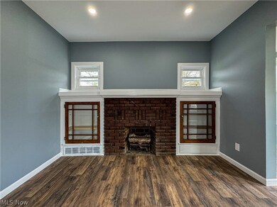 Unfurnished living room with dark hardwood / wood-style flooring, a healthy amount of sunlight, and a fireplace