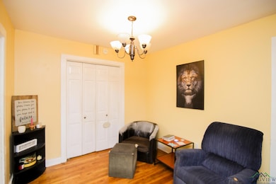 Sitting room featuring a chandelier, wood finished floors, and baseboards