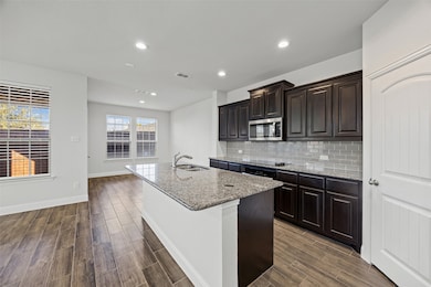Large kitchen with granite counters and stainless appliances.
