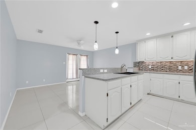 Kitchen featuring a ceiling fan, tasteful backsplash, white cabinets, pendant lighting, and recessed lighting