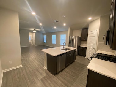 Kitchen with a center island with sink, light sto