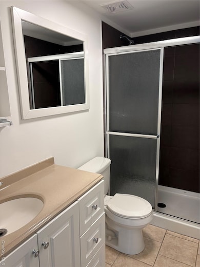 Bathroom featuring vanity, a shower stall, and light tile patterned floors