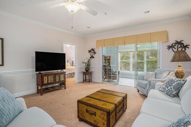 Living room with ornamental molding, light colored