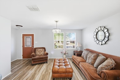 Living area featuring wood finished floors and a chandelier