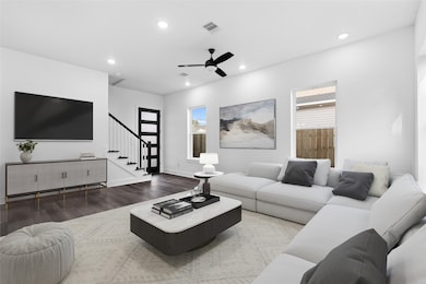 Comfortable staged living space with a sectional sofa and area rug, highlighting the home’s bright and airy feel.