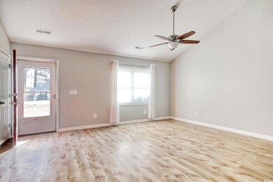 Unfurnished room featuring lofted ceiling, a wealt