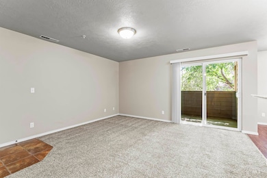 Empty room with a textured ceiling and carpet floors