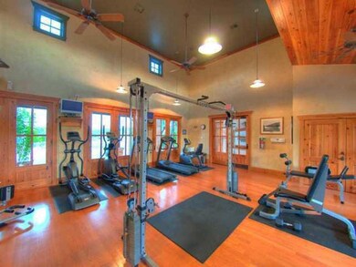Gym featuring ceiling fan, baseboards, high vault