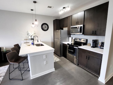 Kitchen with a sink, wood finished floors, a brea