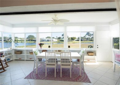 Sunroom with ceiling fan and a water view