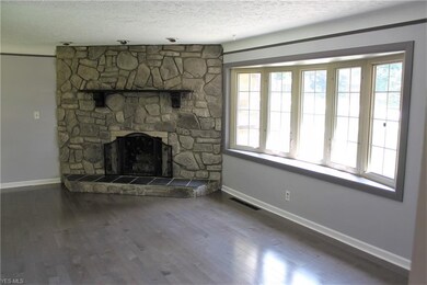 Remodeled wood floors and fresh paint finish out this living room space which features a gorgeous, full wall, stone decorative fireplace.  The bow window also lets in lots of light in this room!