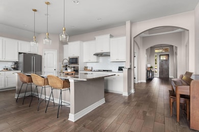 Kitchen featuring arched walkways, decorative bac