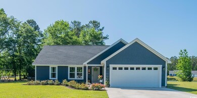 View of front of property with driveway, a front yard, and a garage