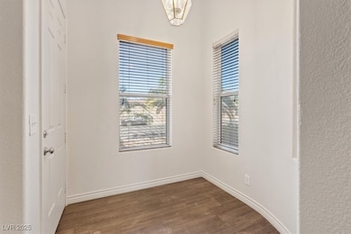 Spare room featuring dark wood-style floors and ba