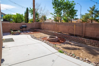 Fenced backyard with a fire pit, a patio area, and