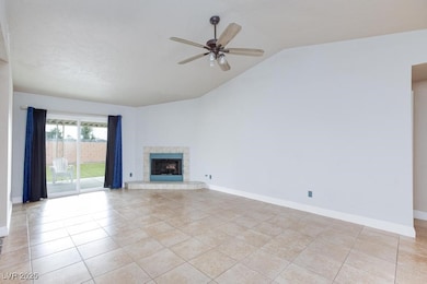 Unfurnished living room with a fireplace, vaulted ceiling, ceiling fan, and light tile patterned floors