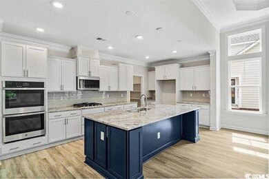 Kitchen featuring ornamental molding, white cabine