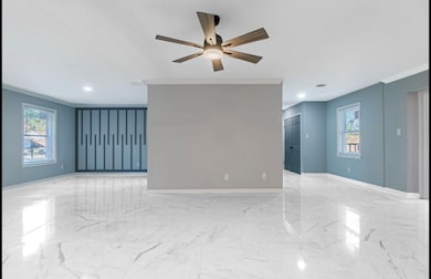 Unfurnished living room featuring ceiling fan and 