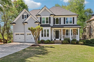 View of front of property with a shingled roof, concrete driveway, covered porch, a front yard, and a garage