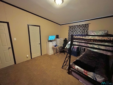 Bedroom with crown molding, light carpet, and lofted ceiling