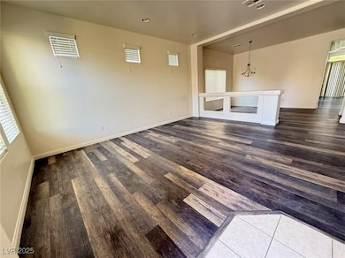 Unfurnished living room featuring a chandelier, da