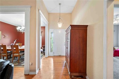 Entrance foyer with light wood-type flooring and a chandelier