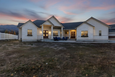 Rear view of house featuring stone siding, board and batten siding, a porch, and french doors