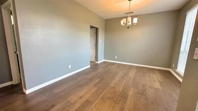 Empty room featuring baseboards, a notable chandelier, visible vents, and hardwood / wood-style flooring
