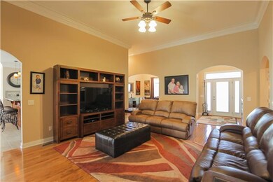 Great room with crown, Neutral colors, lots of arches...view into foyer.