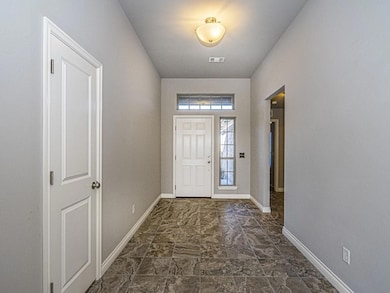 Entrance foyer with baseboards and visible vents