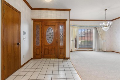 Entryway featuring light colored carpet, crown mol