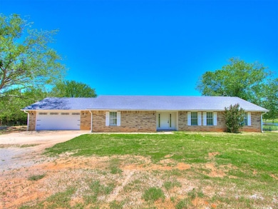 Ranch-style home with driveway, an attached garage, a front yard, and brick siding