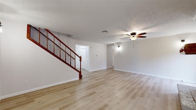 Unfurnished living room with ceiling fan, a textur