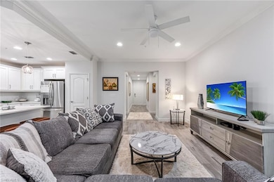 Living room with ceiling fan, light wood-type floo